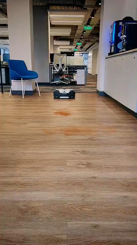 Robot compacto de lavado en pasillo de oficina